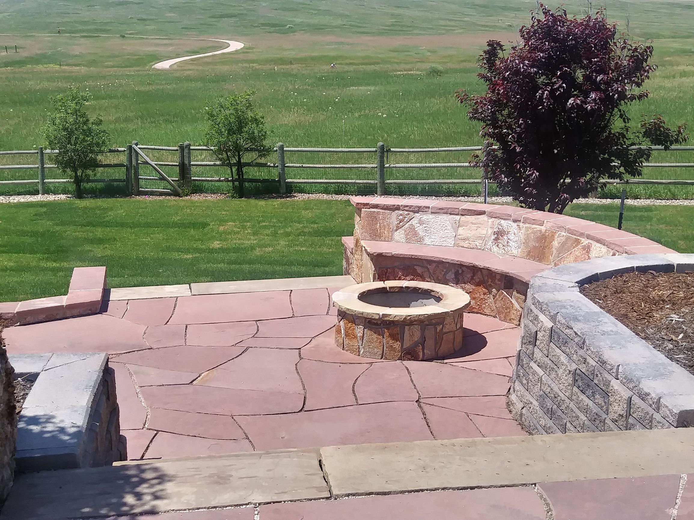 Flat stone patio with Fire pit, and flat stone bench seating surrounding fire pit.