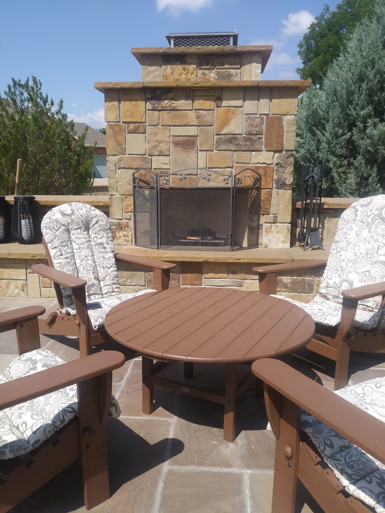 Outdoor Fireplace with large stone chimney and seating area in front.