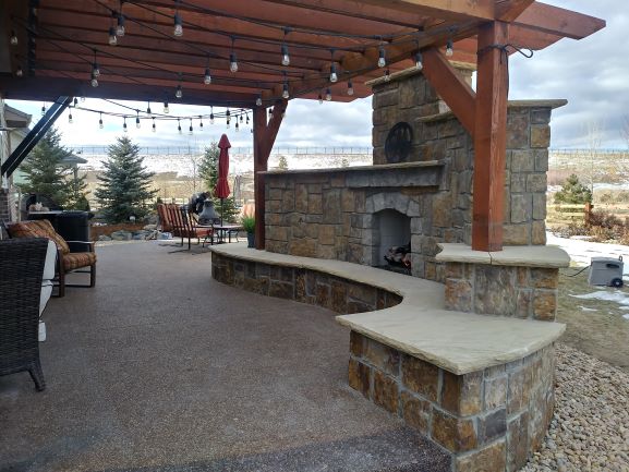 Exterior Fireplace with concrete patio with pergola over top.