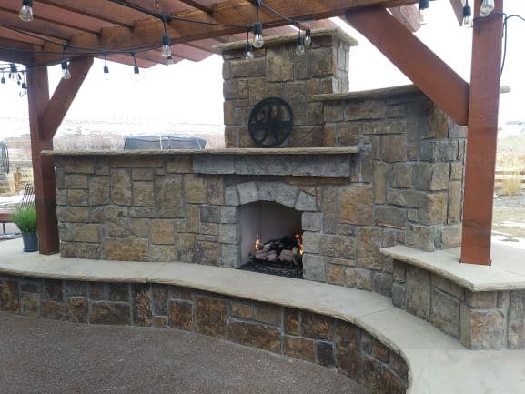 Sturdy Pergola over top exterior Fireplace set in stone.