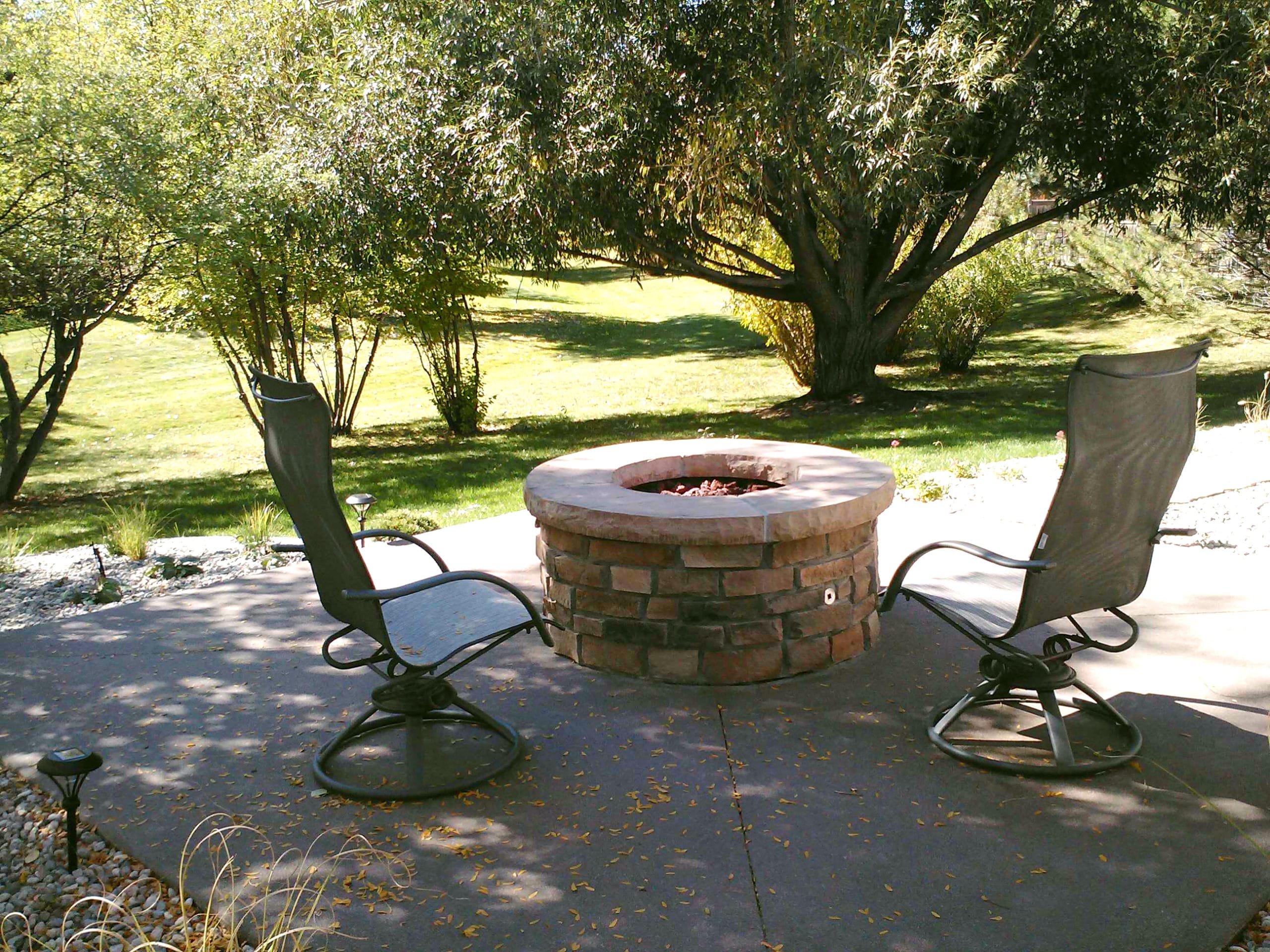 Concrete patio with flat stone fire pit.