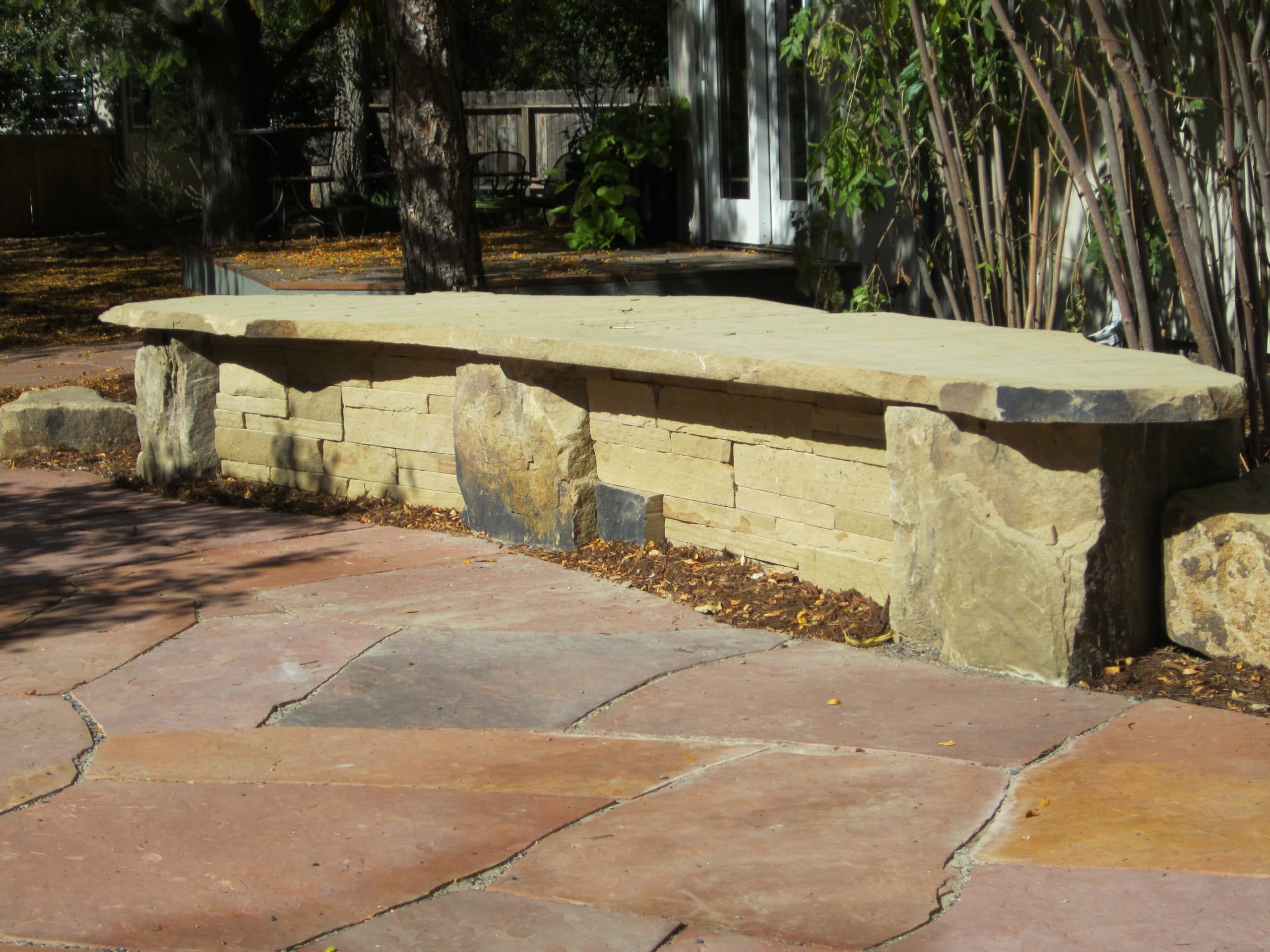 Flat stone patio with a flat stone bench seat.