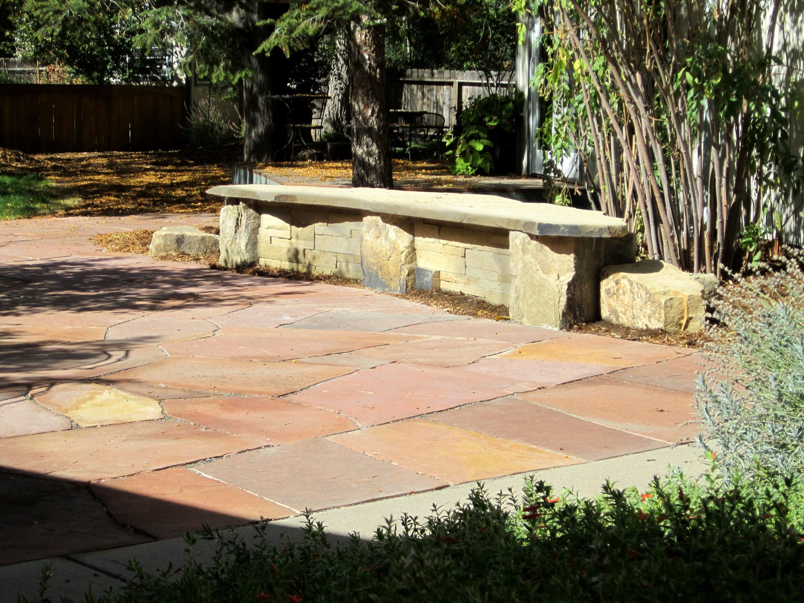 Flat stone patio with a flat stone bench seat.