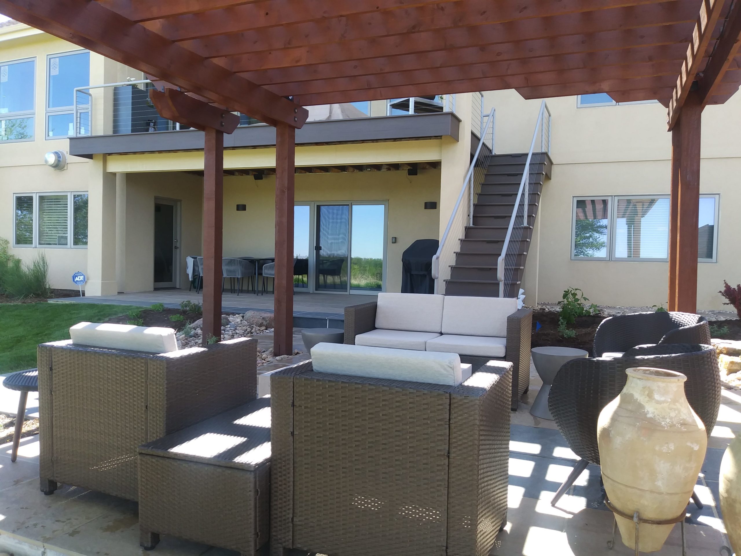 Concrete patio with pergola over top of the seating area.