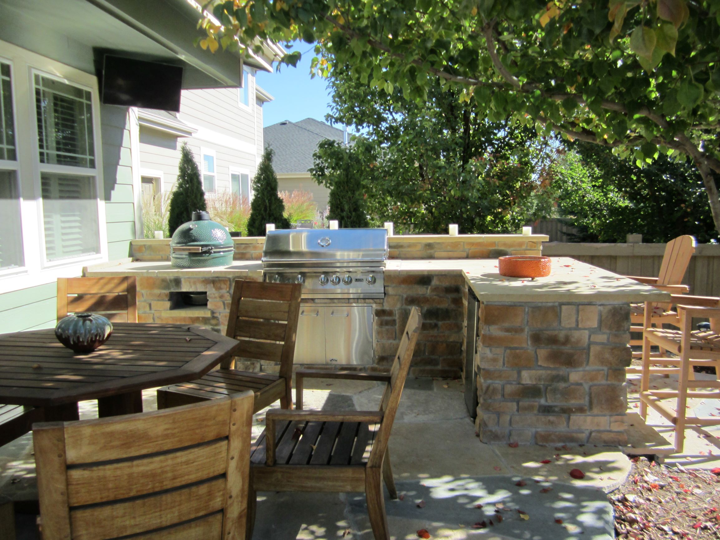 Outdoor grilling station with stone counter tops, adjacent to the outdoor dining area.