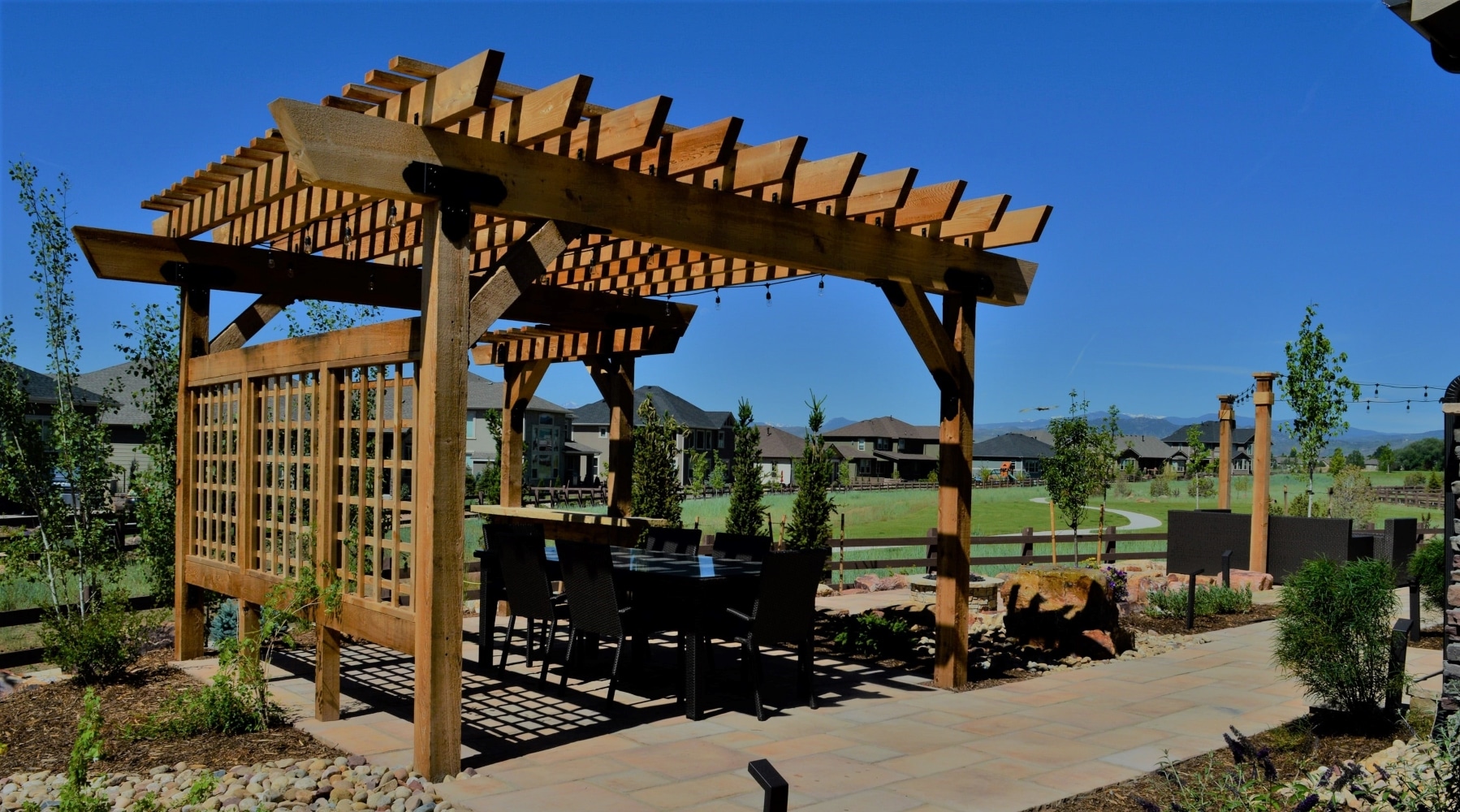 Flat stone patio with pergola over the seating area